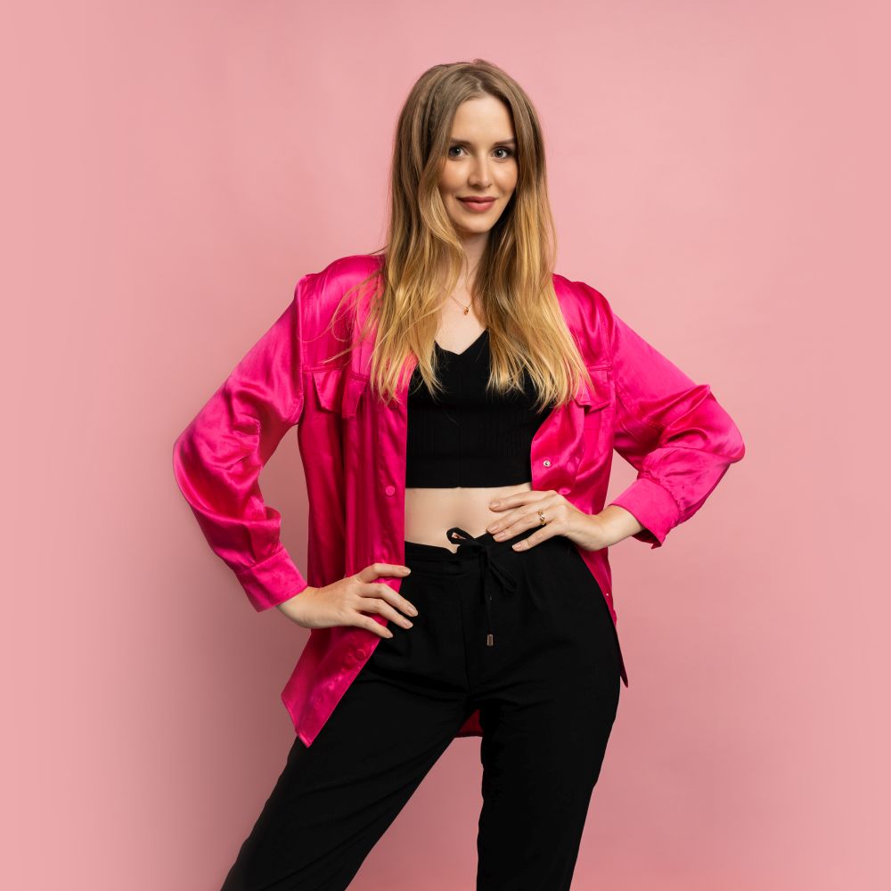 Fasgionable blond woman in stylish summer clothes posing on pink background in studio.
