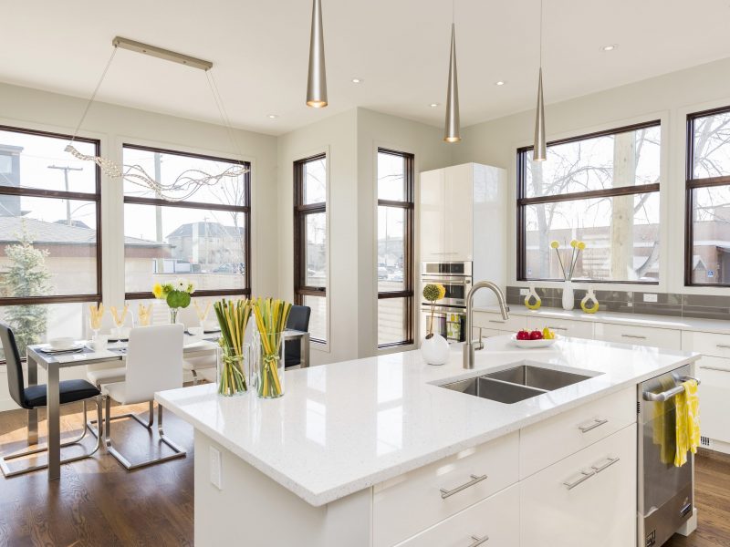 An interior shot of a modern house kitchen with large windows